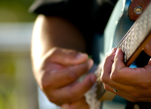 A man plays the guitar at a luau on Maui, Hawaii. (shallow depth of field).