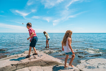 Three children explore a rocky outcrop on Lake Superior