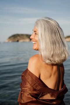 Elegant smiling grey hair mature woman at beach