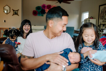 Laughing, happy mother looking at her family in her living room
