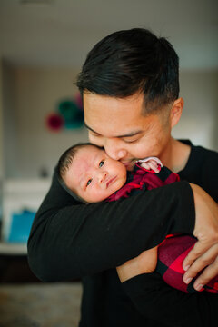 Loving Dad Holding Newborn Son Close To His Face