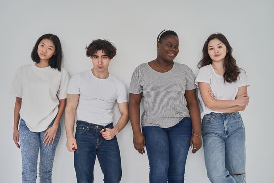 Multiracial models leaning on wall