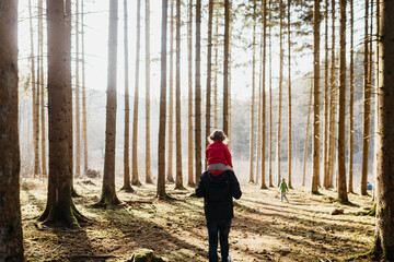 Father carrying his daughter through the woods
