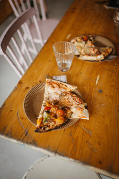 Slices of pizza on a dining room rable