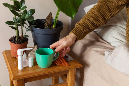 man's hand takes a mug from a chair