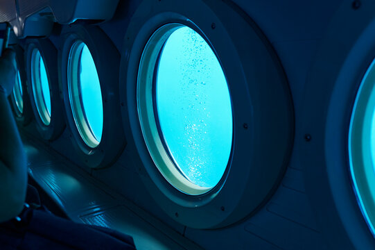 Portholes of a small sub underwater