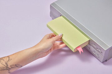 Book being pushed in VCR player by female hand.