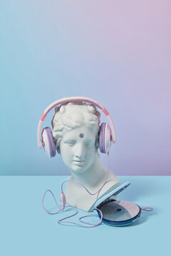 Antique bust in headphones with CD player.