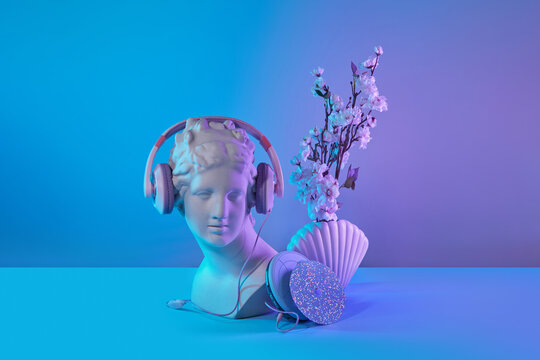 Antique statue in pink headphones and CD player.