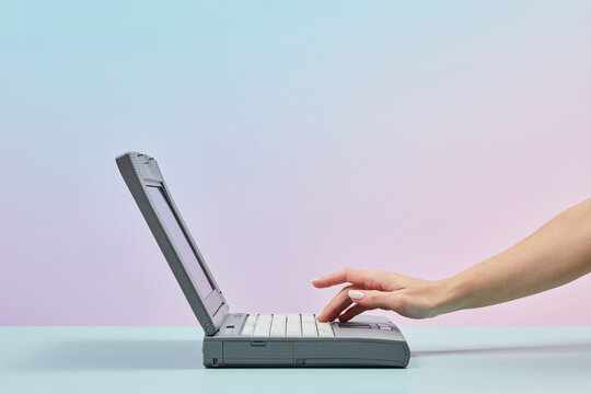 Old Laptop With Woman's Hand Pressing Key.