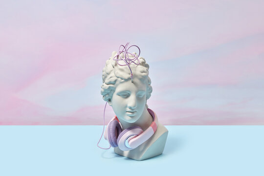 Greek bust entangled in wire of headphones.
