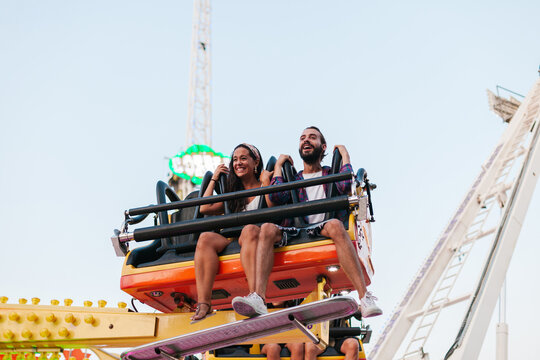 Cheerful man and woman on amusement ride
