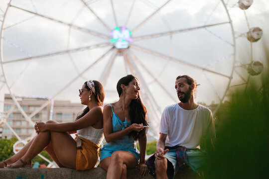 Friends smoking and talking in amusement park