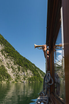 Man playing anthem on a trumpet on a boat