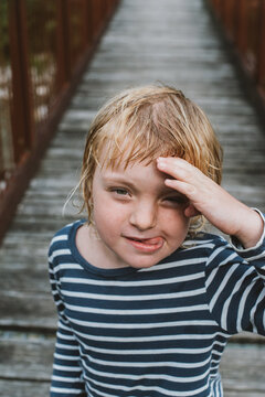 A kid posing on a wooden brodge