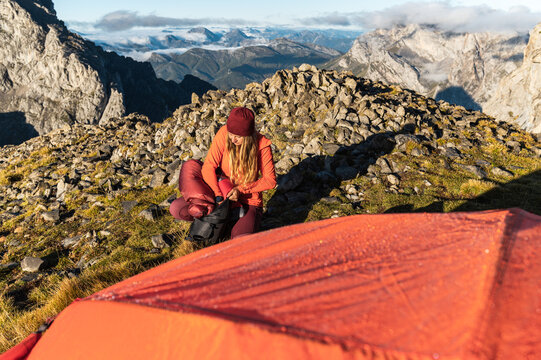 Woman explorer stowing the sleeping bag
