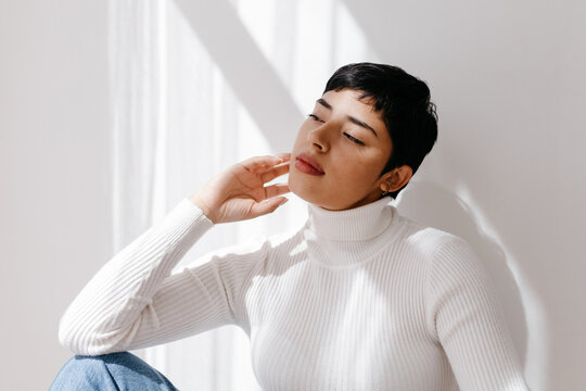 Latin American woman touching face under sunlight