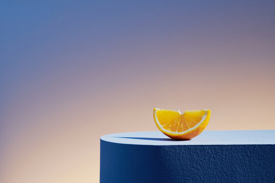 orange slice with hard light and shadows on podium in elegant