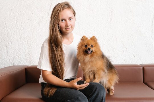 Woman with German Spitz on sofa