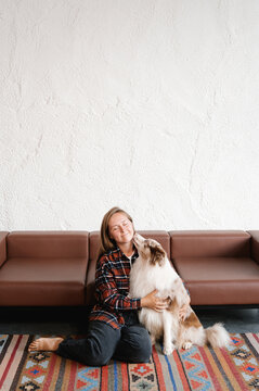 Dog licking face of woman