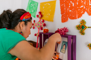 Mexican woman decorating offerings altar