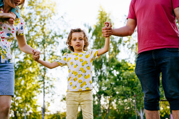 Parents tenderly hold the hand of an autistic daughter