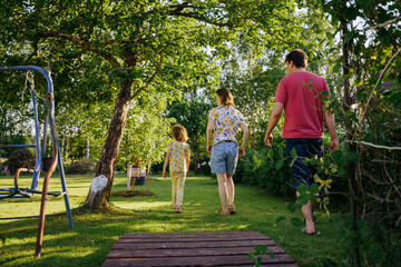 A family with one child walking on the lawn
