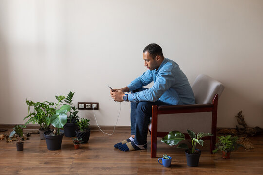 man on armchair with phone