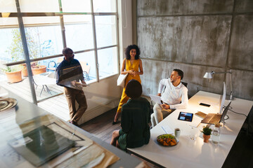 Group of diverse coworkers reviewing documents in office