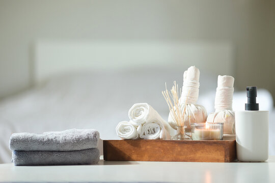 Spa treatment concept. Towels, massage oil, spa herbal compress balls and burning candles on table with copy space.