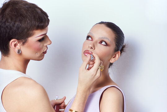 Friends woman With creative Make Up applying lip gloss