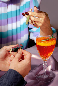 Man Lighting Senior Woman's Marijuana Joint