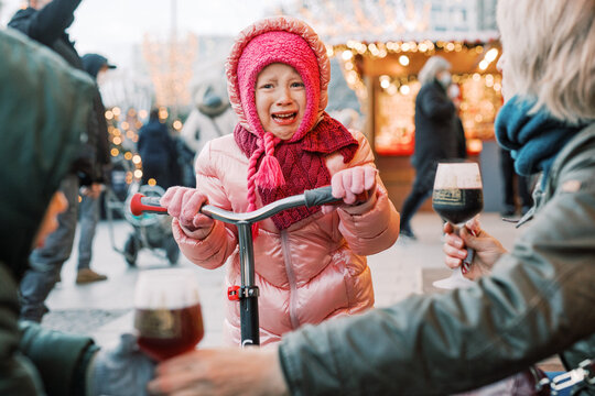 Little girl in pink being miserable at the Christmas market 