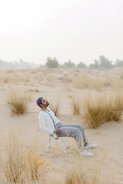 A melancholic man on the chair in the desert