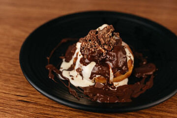 Dessert - Sonho - Typical Brazilian sweet produced in bakeries - Bread sprinkled with sugar and stuffed with vanilla cream, with chocolate sauce and ice cream