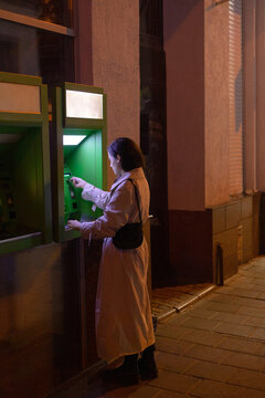woman inserting a card into a bank terminal