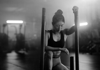 Young Asian female training in gym with weights at night