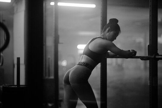 Young Asian female training in gym with weights at night