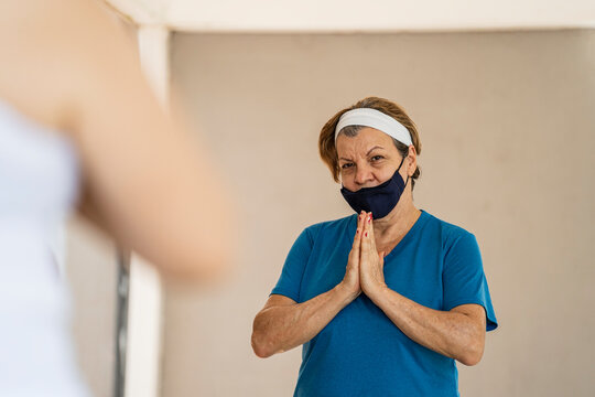 adult woman clasping her hands together in yoga class
