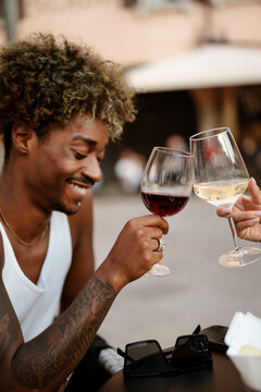 A happy afro-haired man at the bar with a friend
