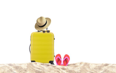 Yellow luggage with hat and red flip-flop on sandy beach 