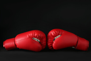 Red boxing gloves on black marble table. Competition concept