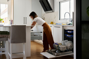 Woman doing housework in kitchen.