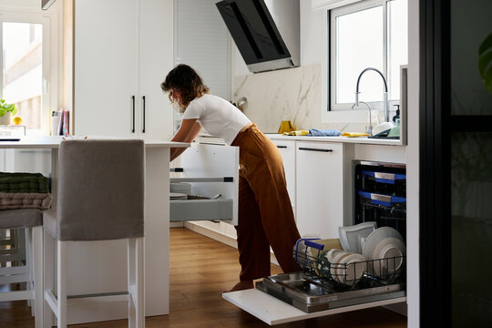 Woman doing housework in kitchen.
