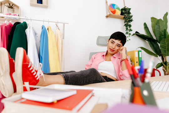 Dreamy female designer resting at desk