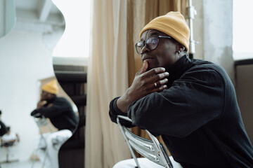 a man in a yellow hat in his creative studio