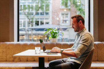Smiling black man working on laptop