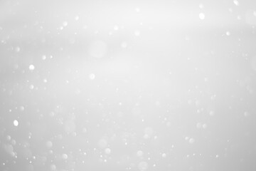 White glitter vintage lights background.  White bokeh shiny on dark background.