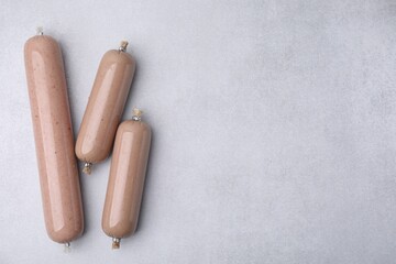 Delicious liver sausages on white table, flat lay. Space for text
