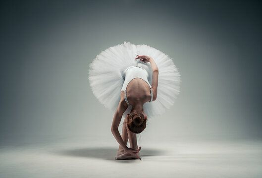 Fototapeta young ballerina girl on a white background